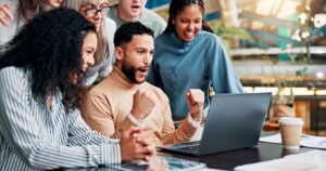 Happy people gathered around a computer